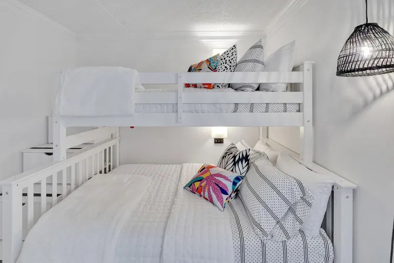 white wooden bunk beds with hanging black lamp