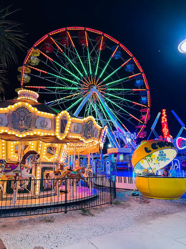 night time lights on ferris wheel and carousel